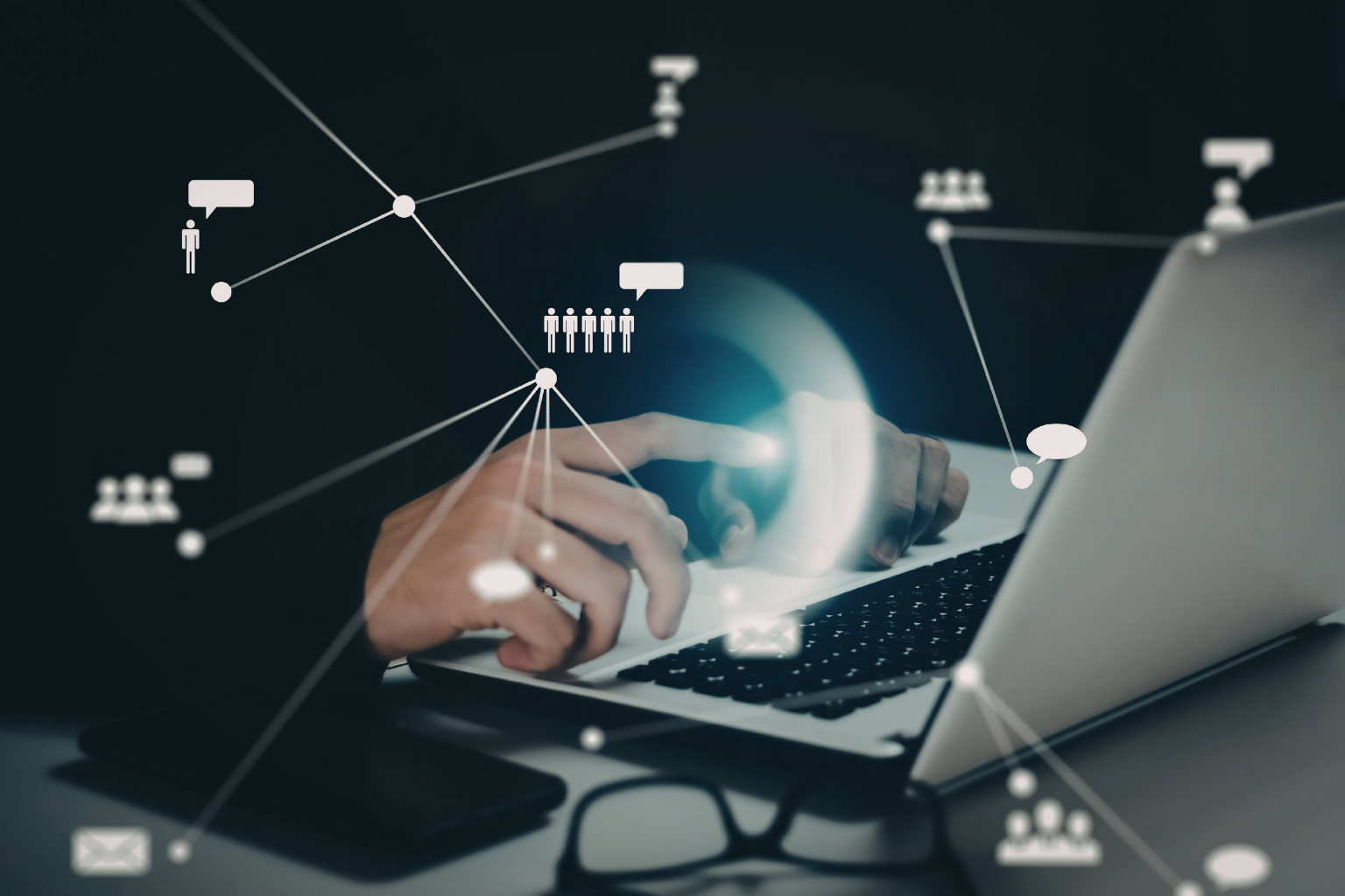 Hands typing on a laptop surrounded by a connected network of people and communication icons, representing workforce intelligence and talent data connectivity.